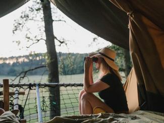 Een vrouw in een tent met uitzicht over de Ardennen