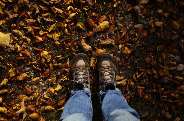 Mit den Füßen in den Herbstblättern