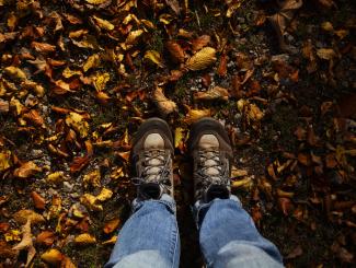 Mit den Füßen in den Herbstblättern